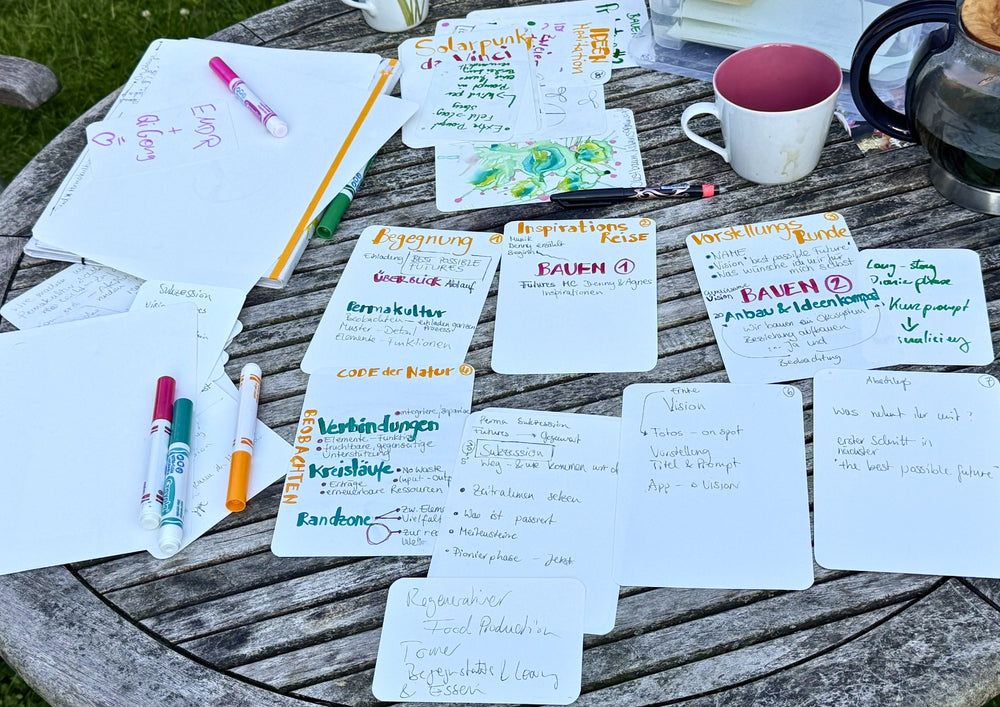 Written cards, pens and a jug on a wooden garden table.