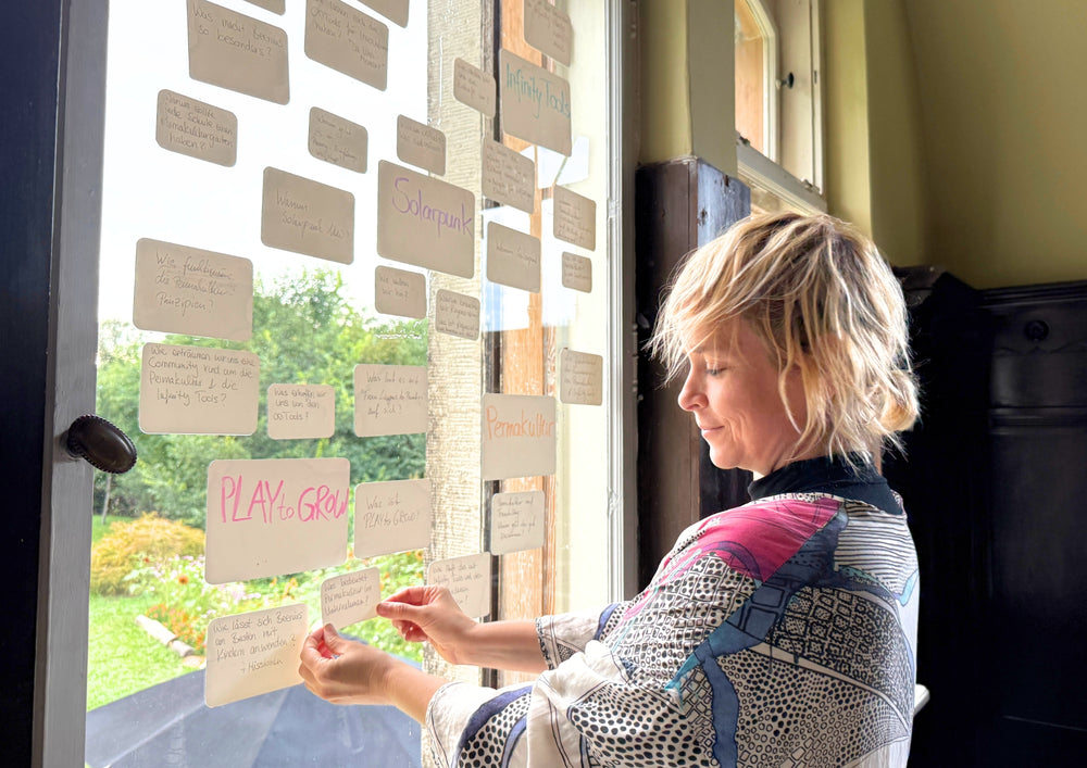 Woman hanging a card on a glass front where many written cards are already clinging.