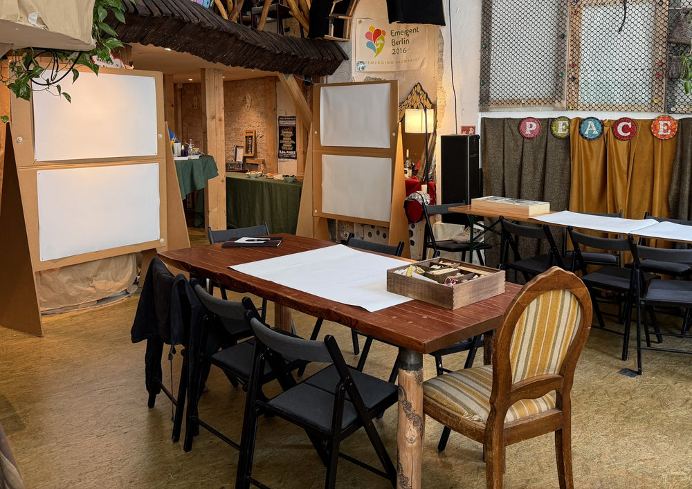 Prepared work table with pale sheets, partition walls and shelves behind it.