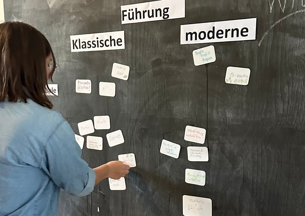 Woman arranging written cards on a black chalkboard.