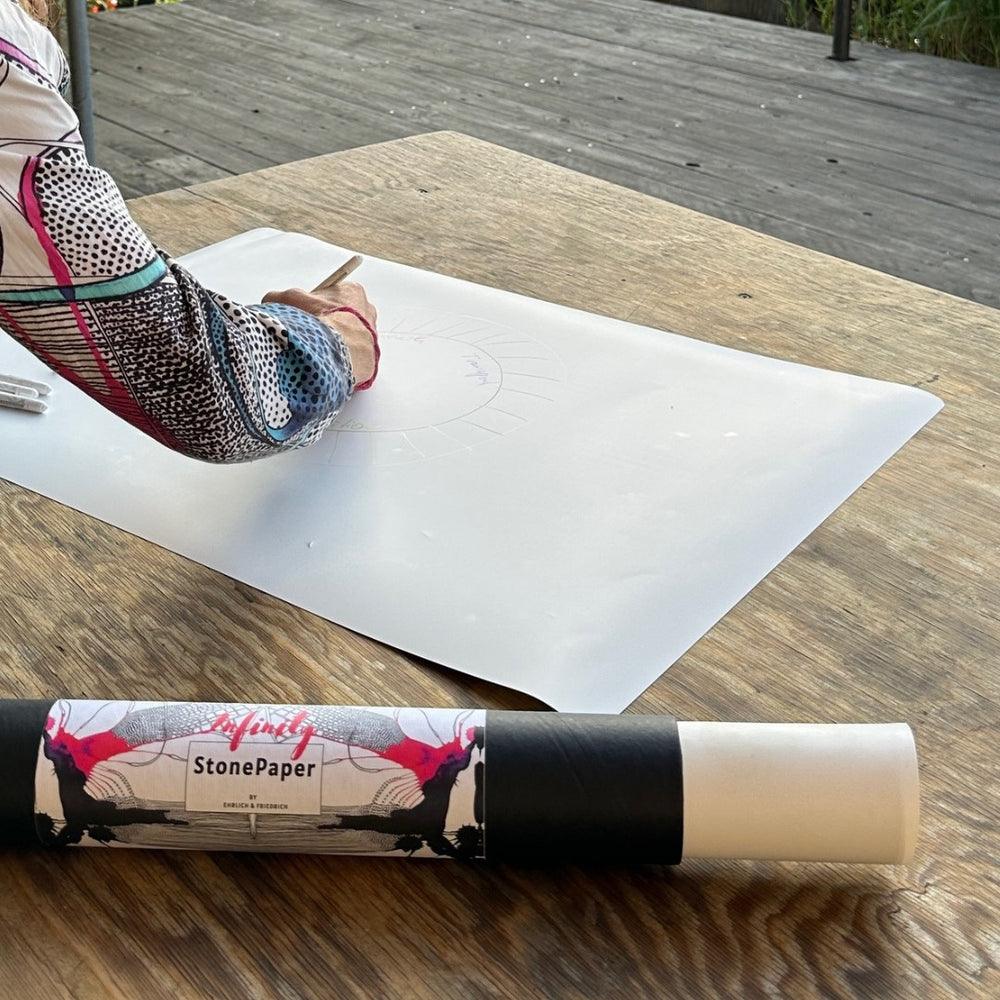 Board lying next to the carrying tube on a wooden table outdoors.