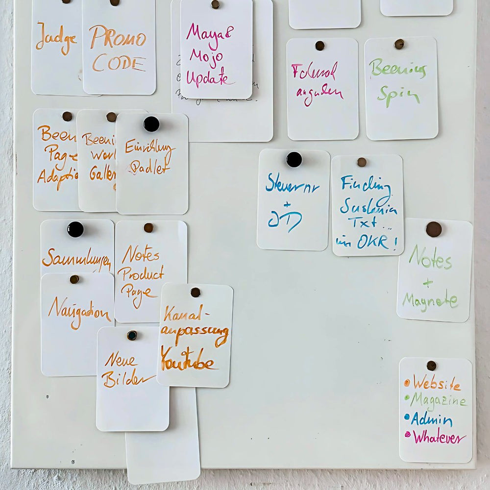 Written Notes held by magnets in rows on a metal board.